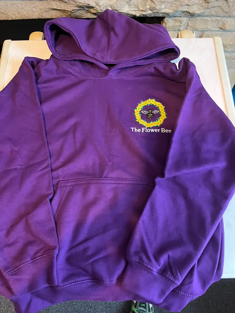Purple children's hoodie embroidered with The Flower Bee logo on the chest